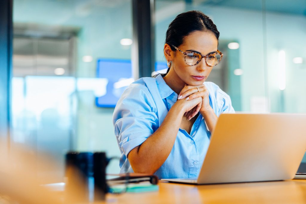 businesswoman focusing intently on her laptop in a professional office setting