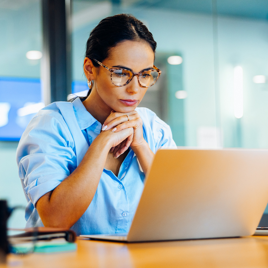 businesswoman focusing intently on her laptop in a professional office setting