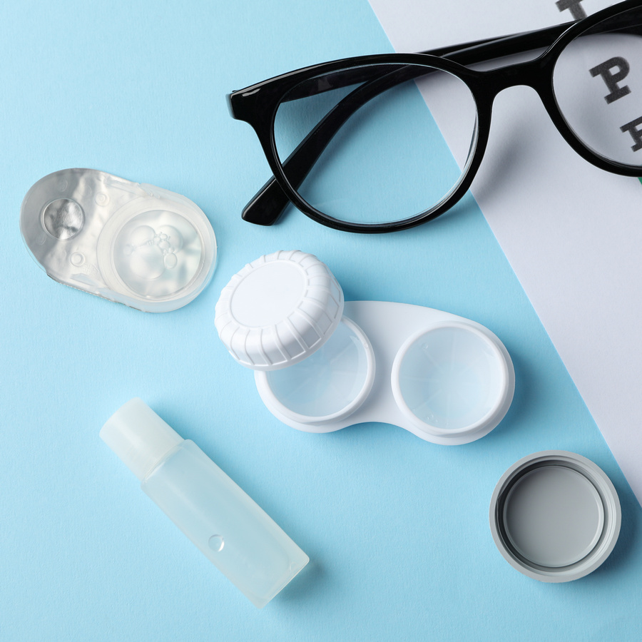 glasses, contact lenses and eye test chart on blue background, t